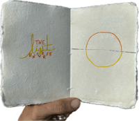 a hand holding a book with a circle drawn on it